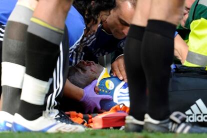 Drogba es atendido sobre el terreno del juego tras la caída que ha sufrido.