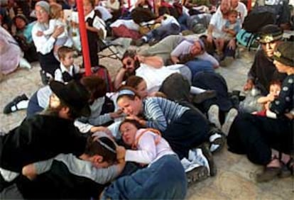 Feligreses judíos se lanzan al suelo durante el tiroteo, provocado por pistoleros palestinos, en la ciudad de Hebrón (Gaza).