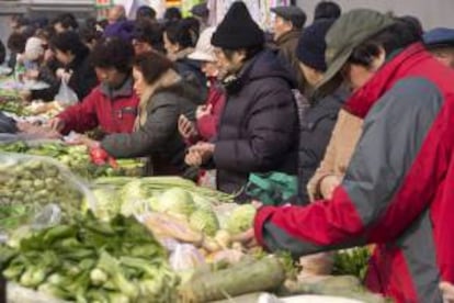 Residentes realizan compras en un mercado en el centro de Pekín. EFE/Archivo