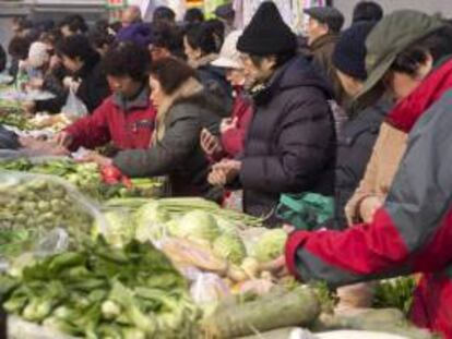 Residentes realizan compras en un mercado en el centro de Pekín. EFE/Archivo