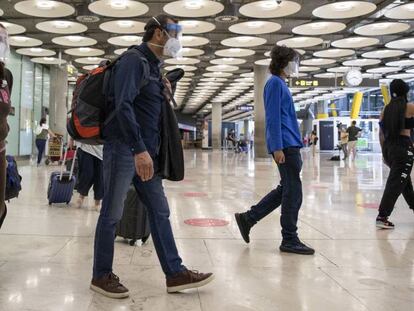 Pasajeros en los pasillos del aeropuerto de Madrid, en junio. 