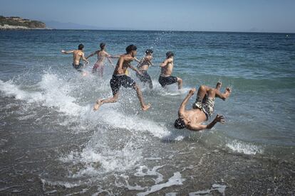 Un grupo de jóvenes aprovecha la mañana para bañarse en la playa junto a los educadores sociales ceutíes. Se calcula que entre el 17 y el 19 de mayo entraron unos 1.500 menores de edad en Ceuta. La ciudad acoge un mes después a más de 800 en varias instalaciones, entre ellas un polideportivo municipal y una nave en un polígono industrial. La mayoría de los padres en Marruecos no desean que regresen.