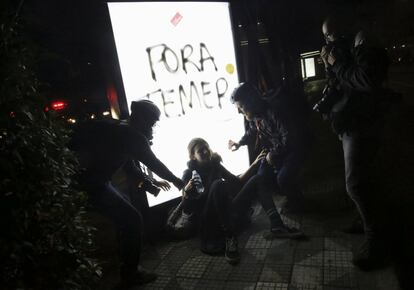 Un grupo de fotógrafos ayudan a una mujer gaseada durante una protesta en contra del nuevo presidente de Brasil, Michel Temer, en Río de Janeiro (Brasil).