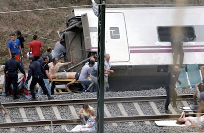 Sanitarios y vecinos atienden a los heridos en el lugar del accidente donde el tren Alvia descarriló (inmediaciones de Santiago de Compostela), en julio de 2013.