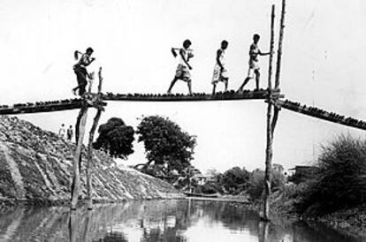 Unos campesinos cruzan un precario puente en los alrededores de la capital de Bangladesh, Dhaka, en 1988.