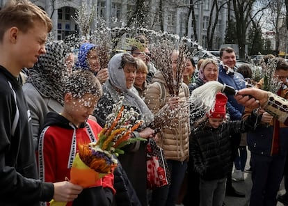 An Orthodox priest sprays holy water on believers after a service which marks the Orthodox feast of Palm Sunday