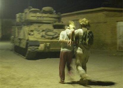 Un soldado de la Cuarta División de Infantería conduce a un detenido anoche en Tikrit a un vehículo militar.