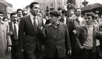 El presidente del Gobierno, Adolfo Su&aacute;rez, camina junto a un ciudadano en una calle durante su campa&ntilde;a en Galicia, en las elecciones legislativas.
 