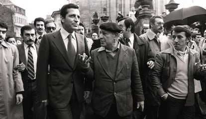 El presidente del Gobierno, Adolfo Suárez, camina junto a un ciudadano en una calle durante su campaña en Galicia, en las elecciones legislativas.
