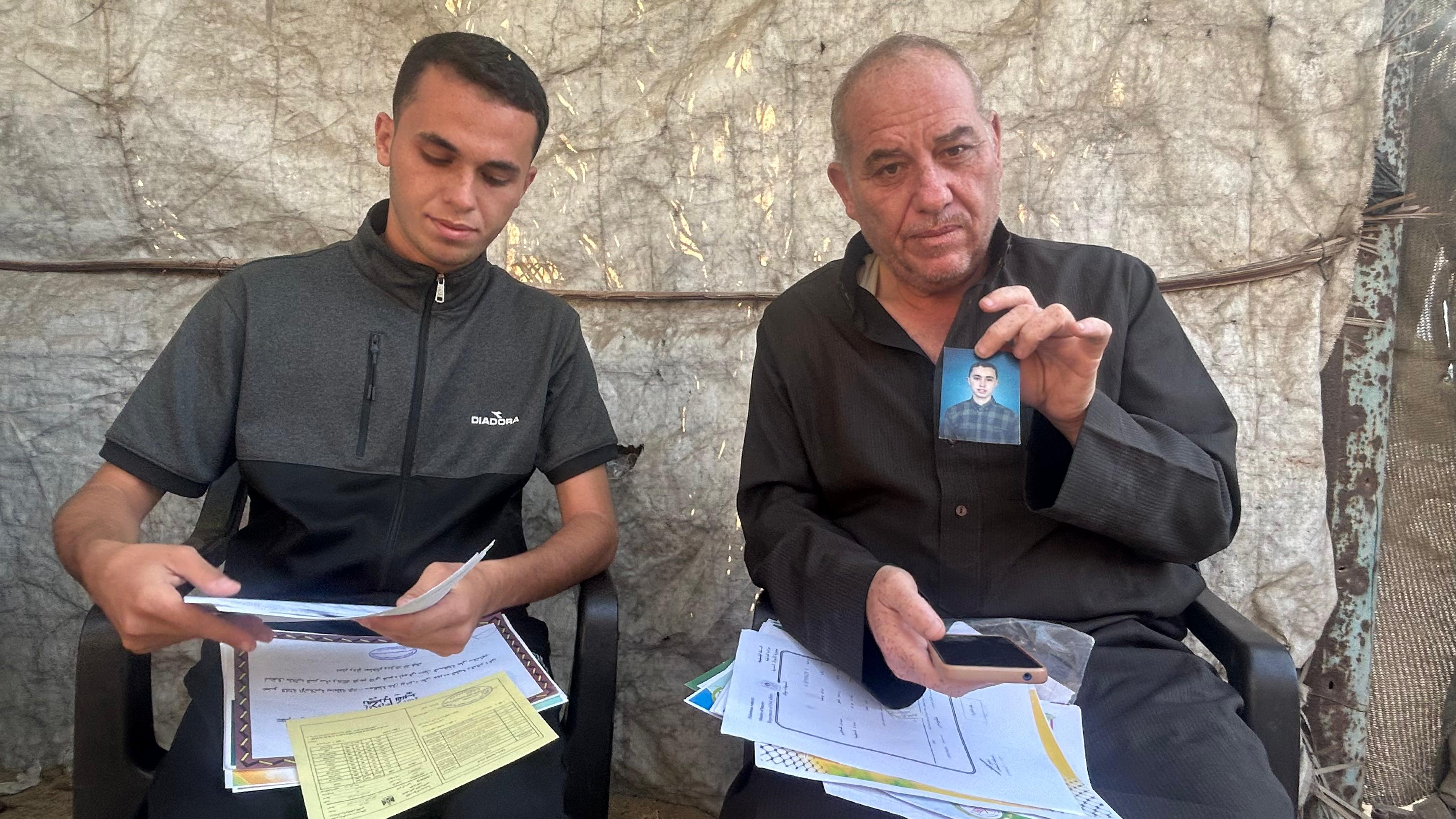 Youssef Shabeer, de 51 años, veterinario y padre de ocho hijos, en el refugio para desplazados de su familia en Jan Yunis, el 8 de octubre. Sostiene una foto de su hijo mayor, Zakaria, asesinado días antes de que entrara en vigor el alto el fuego.