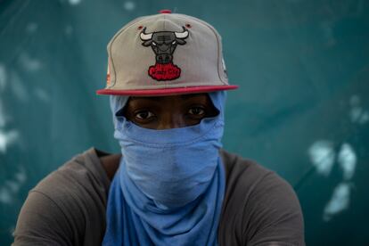 Wilson Joseph cubre su rostro con una camiseta frente a la tienda de campaña donde duerme en Ciudad Acuña.