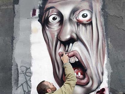 Un grafitero pinta en una fachada