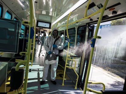 Un operario de la EMT desinfecta con un nebulizador un autobús de línea de la Empresa Municipal de Transportes de Madrid.