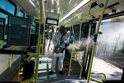 Un operario de la EMT desinfecta con un nebulizador un autobús de línea de la Empresa Municipal de Transportes de Madrid.