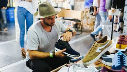 Un hombre ojea zapatillas en el Mercado de Diseño Spring Edition, en Madrid.