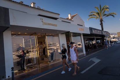 Una pareja pasea por una de las calles comerciales de Puerto Banús, en Marbella, el 28 de julio.