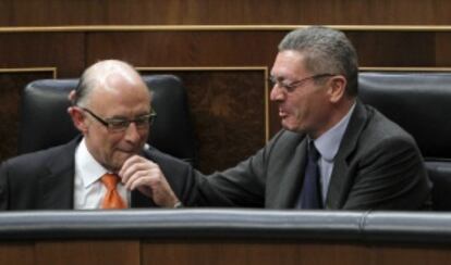 El ministro de Justicia, Alberto Ruiz-Gallardón, felicita al ministro de Hacienda, Cristóbal Montoro, tras su intervención en el Congreso.