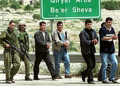 Dos soldados israelíes escoltan a varios palestinos maniatados, detenidos durante las operaciones militares en Belén.