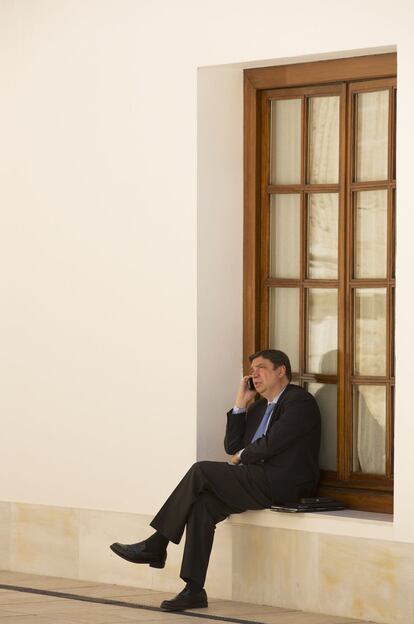 Luis Planas hablando por teléfono en el Parlamento de Andalucía.