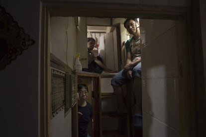 Los residentes Lam, arriba a la izquierda, Wan, arriba a la derecha, y Kitty Au, posan en sus hogares ataúd.