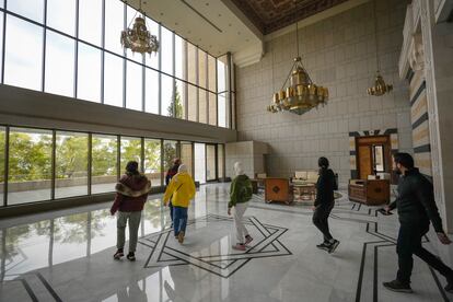 Un grupo de sirios pasea por el interior del palacio presidencial este domingo. 