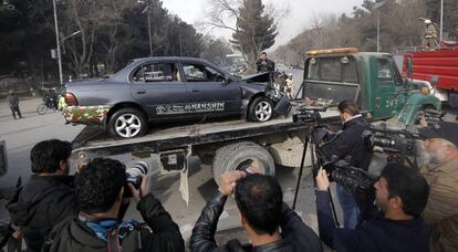 Las fuerzas de seguridad afganas retiran un vehículo dañado tras la explosión en Kabul.