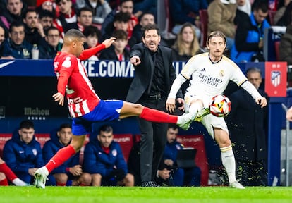 Lino y Modric disputan un balón durante el encuentro de esta noche, con Simeone de fondo.