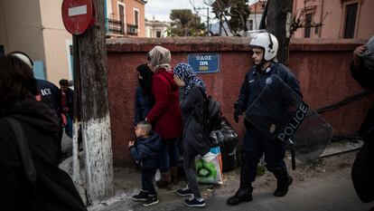 Un policía griego escolta a una familia, ayer en Mitilene. / A. GARCÍA