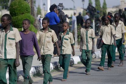 Alguns dos estudantes nigerianos que ficaram seis dias sequestrados caminham em fila em direção a um prédio do Governo, após serem libertados, nesta sexta-feira, na cidade de Katsina.