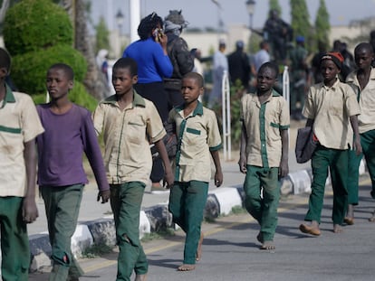 Alguns dos estudantes nigerianos que ficaram seis dias sequestrados caminham em fila em direção a um prédio do Governo, após serem libertados, nesta sexta-feira, na cidade de Katsina.