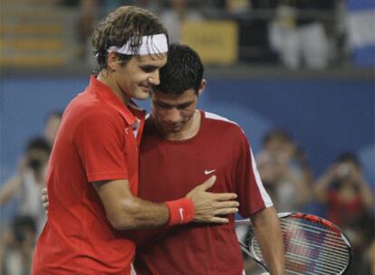 Roger Federer abraza a Rafael Arévalo tras el partido de ayer.