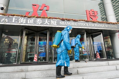 Técnicos sanitarios desinfectan la entrada principal de la Bolsa de Shangái.