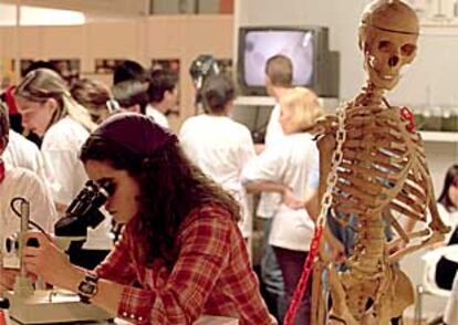 Una chica observa por uno de los microscopios de la feria Madrid con la ciencia.