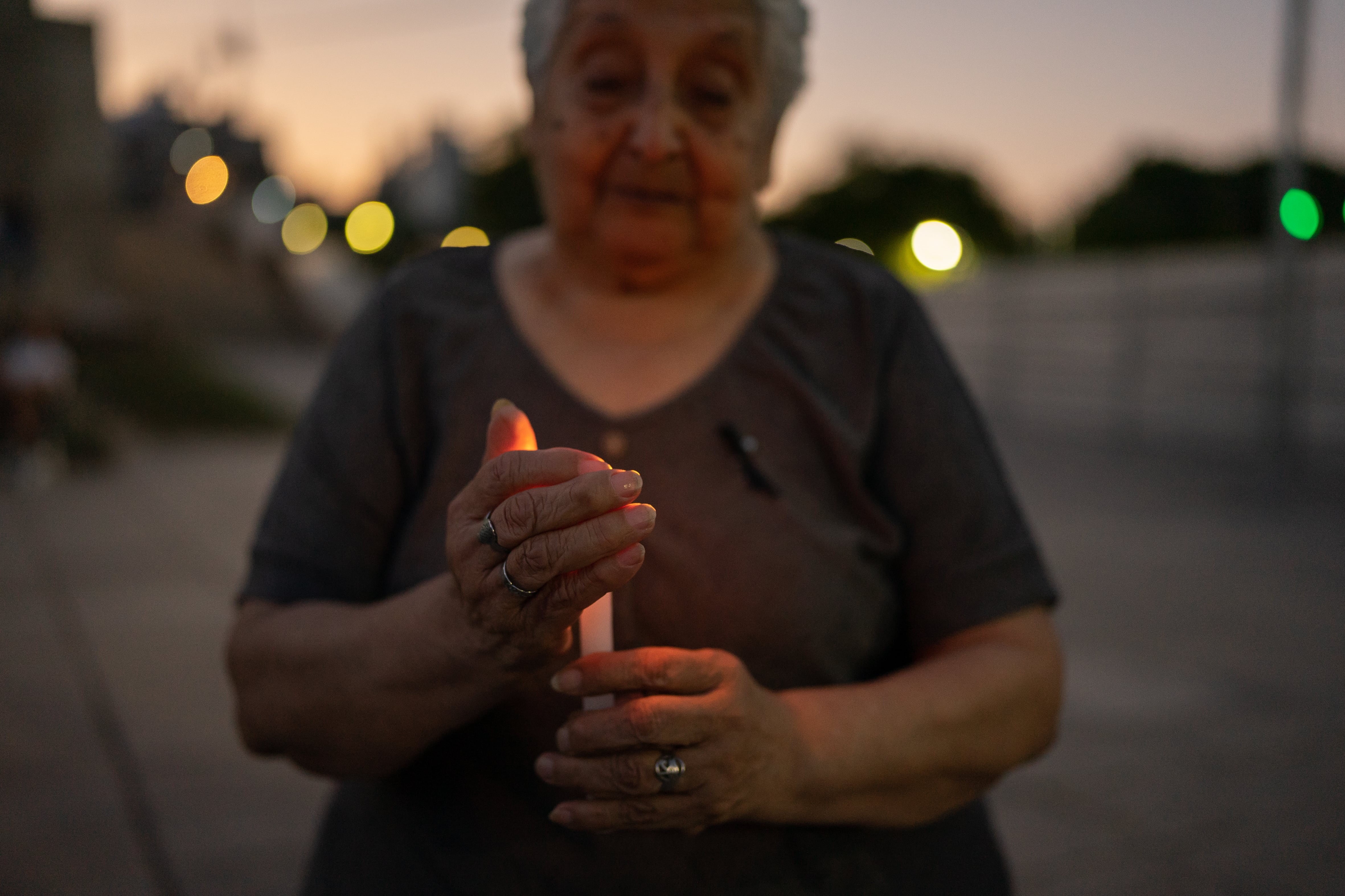 Una mujer sostiene una vela encendida, en Rosario.