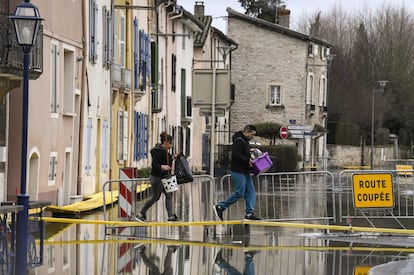 El sena ha alcanzado un pico de 4 metros de crecida respecto a su caudal habitual. En la imagen, dos personas cruzan por un camino de tablas instalado por las inundaciones en Tournus (Francia), el 29 de enero de 2018.