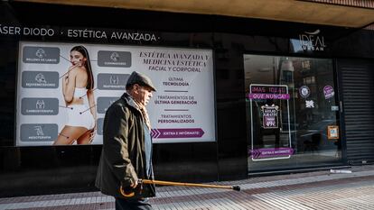 Un hombre camina delante de un establecimiento cerrado de Centros Ideal en el centro de Madrid.