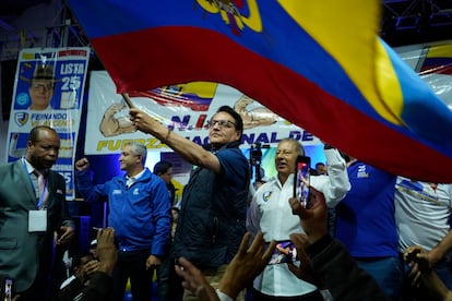 El candidato presidencial Fernando Villavicencio ondea una bandera ecuatoriana durante un acto de campaña en una escuela minutos antes de ser asesinado a tiros.