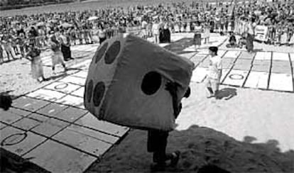 Un grupo de niños durante el concurso de parchís gigante delebrado ayer en la playa de la Concha.