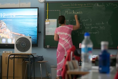 Una profesora da clase en inglés junto a un ventilador en un colegio de Madrid.