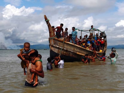 Un grupo de refugiados rohingya cruza en barco desde Myanmar (al fondo, con humo) a Bangladés, este lunes.