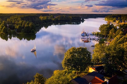 La hermosísima región de <a href="https://www.polonia.travel/es" target="_blank"> la llanura lacustre de Masuria, en Polonia</a>, no tiene límites precisos; y tampoco debería de tenerlos el tiempo de vacaciones que se pase en este idílico humedal. Sus bosques y prados son un magnifico escenario para no hacer, literalmente, nada y entregarse al descanso. Si nos atrapa la pereza o el aburrimiento, siempre se puede alquilar una bicicleta o una piragua y deleitarse con unos espléndidos paisajes. O bien visitar alguna de las bonitas ciudades de la zona, como Giżycko, Mikołajki o Pisz. En otros tiempos, Masuria formaba parte de la Prusia Oriental, poblada desde el siglo XII principalmente por eslavos mazovios de los cuales recibió el nombre, aunque luego fue incorporada a Alemania y pasó a formar parte de Polonia tras la II Guerra Mundial. A día de hoy, en esta región de 10.000 kilómetros cuadrados y casi 60.000 habitantes aún perdura una importante huella alemana.