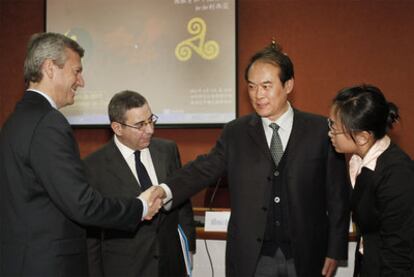 El conselleiro de Presidencia, Alfonso Rueda, junto a Pablo Figueroa, el director de la delegación china Huang Xing y una traductora.