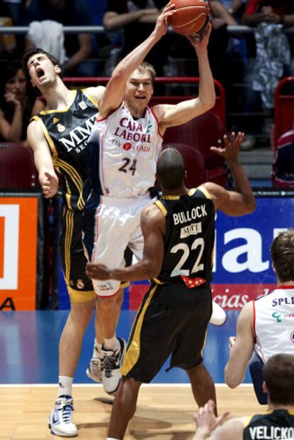 El escolta estadounidense del Caja Laboral Baskonia Brad Oleson intenta un pase ante Louis Bullock y Ante Tomic.