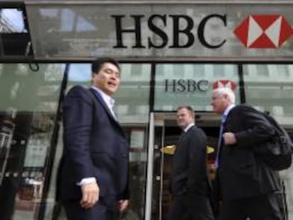 Tres hombres pasan junto a una sucursal del banco británico HSBC en Londres, Reino Unido. EFE/Archivo