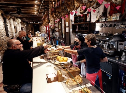 Un usuario pide un pincho en la barra de un bar de Pamplona. 
