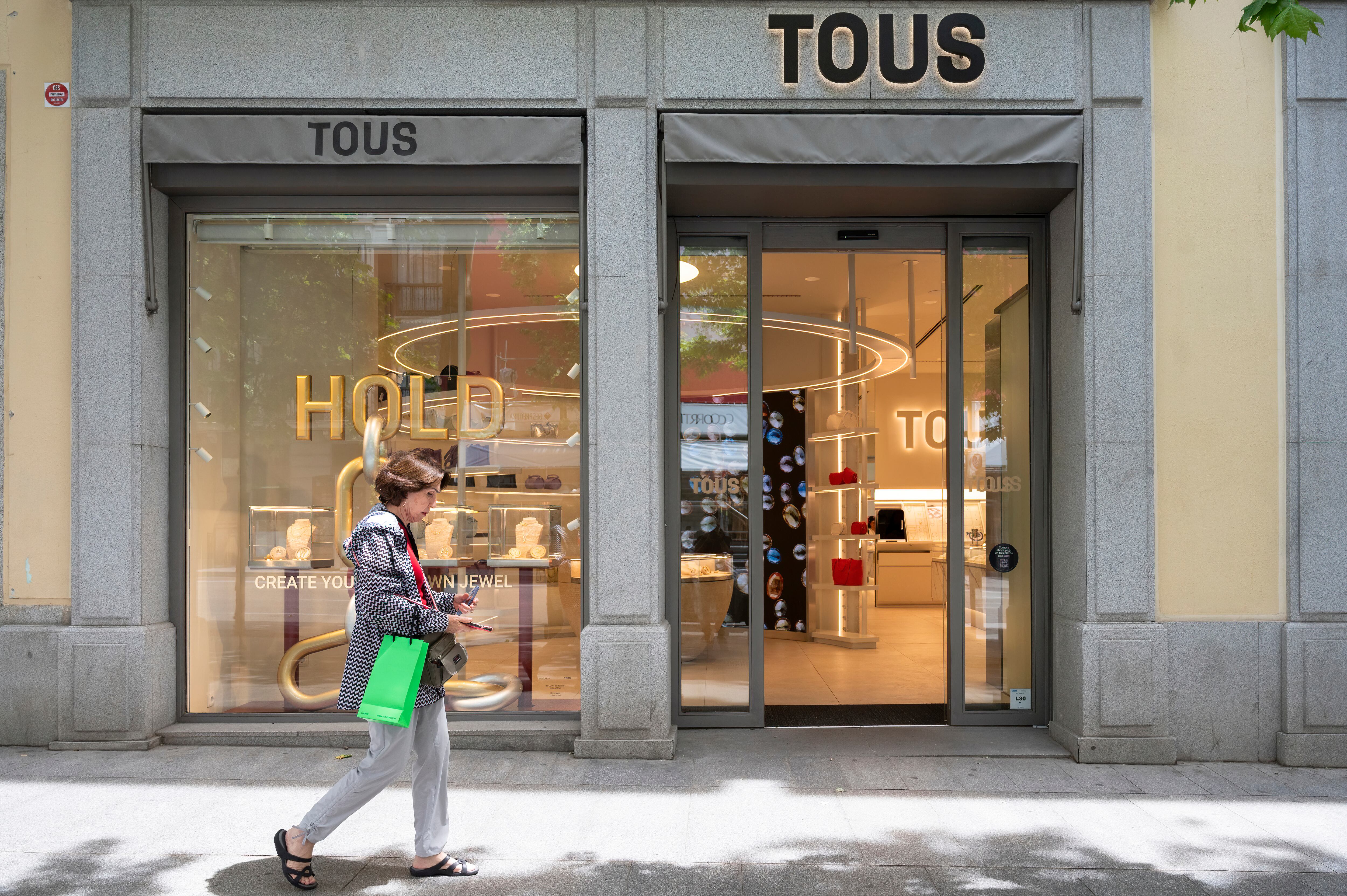 Una mujer pasa por delante de una tienda de la compañia de joyas Tous en Madrid