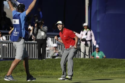 Jon Rahm y su caddie, Adam Hayes, celebran el eagle en el 18.