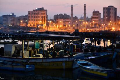 Las luces de la calle iluminan el horizonte de Gaza mientras el sol se levanta para dar la bienvenida a un nuevo día cuando los pescadores traen su captura al puerto de la ciudad de Gaza, el 14 de febrero de 2019. Los pescadores tan solo pueden alejarse unos pocos kilómetros de la costa para no ser detenidos por las fuerzas israelíes.