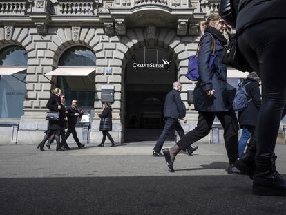 Viandantes caminan junto a la entrada de la sede global de Credit Suisse, situada en Zúrich, este jueves.