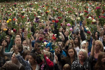 Miles de personas homenajean con rosas a los muertos en la matanza de Oslo y la isla de Utoya, ayer frente al Ayuntamiento de la capital noruega.